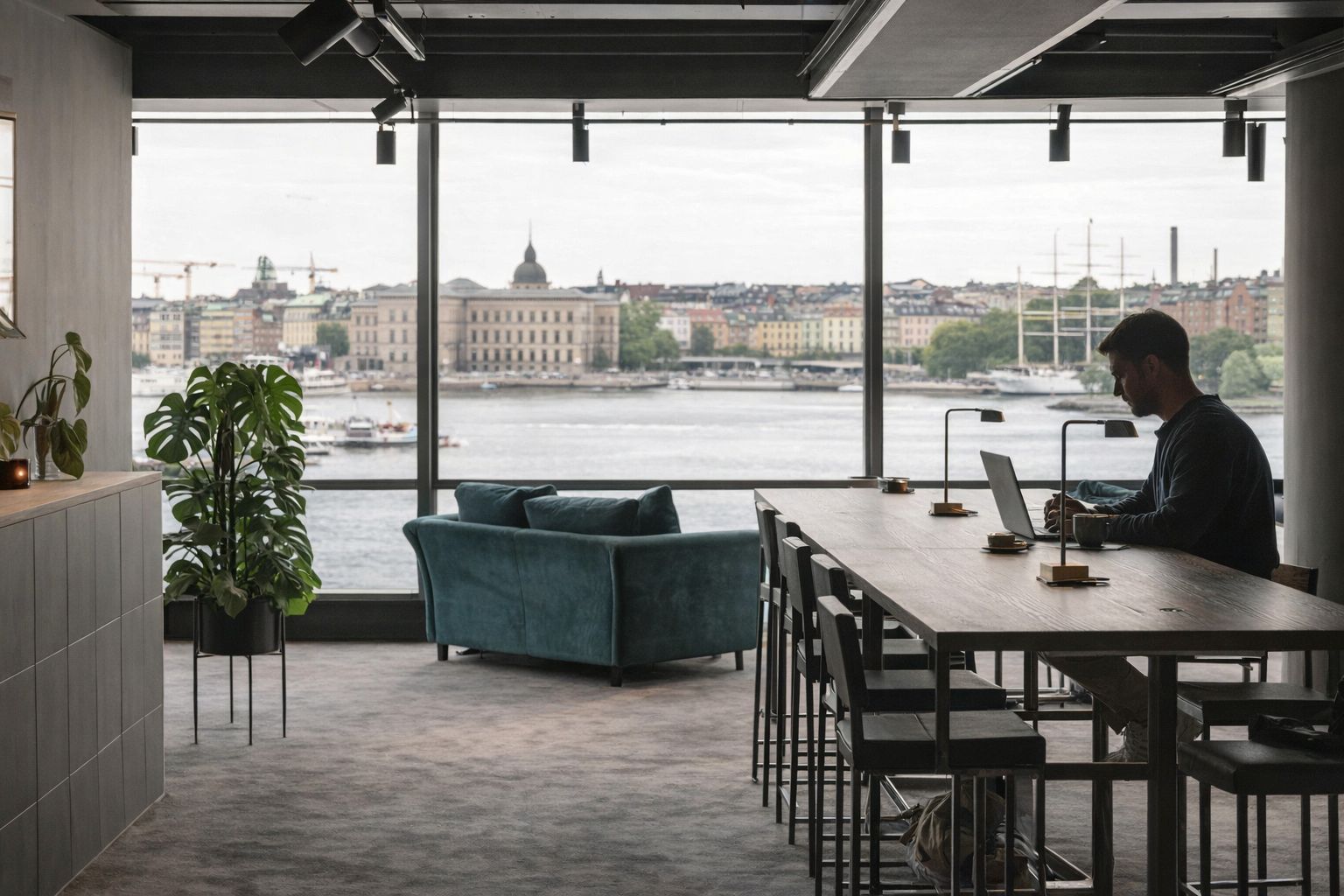 Man arbetar vid en laptop i ett modernt coworking space i Stockholm.