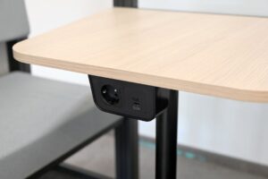 Eluttag och USB-portar diskret monterade under en ljus träskiva